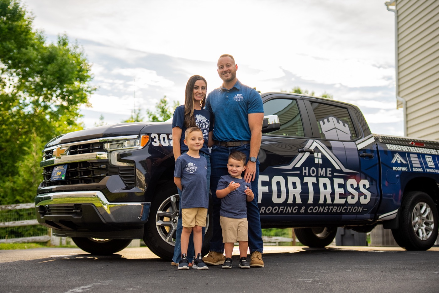 Randy Shepheard and his family in front of a Home Fortress Roofing & Construction truck